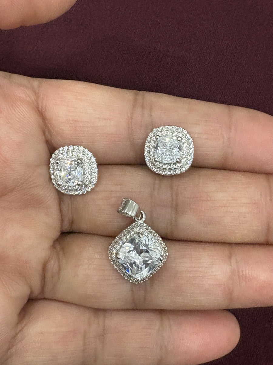 Pendant and earrings set with cushion-cut clear stones and halo detailing, chain not included.
