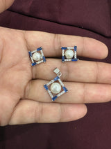 Pendant and earrings set with pearl centers and blue baguette accents in a square design