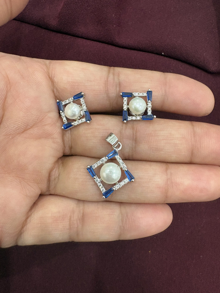 Pendant and earrings set with pearl centers and blue baguette accents in a square design